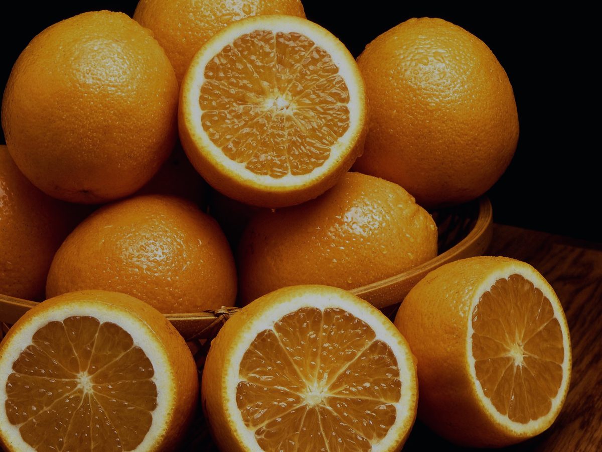Oranges in a basket, some cut in half